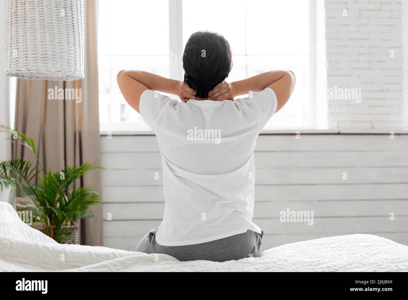 Man suffering from neck pain at home in bedroom Stock Photo - Alamy