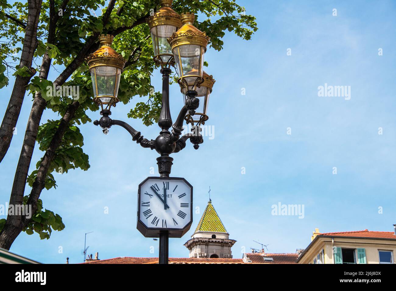 An ornate street light and clock in the flower Market, Nice, France. Stock Photo
