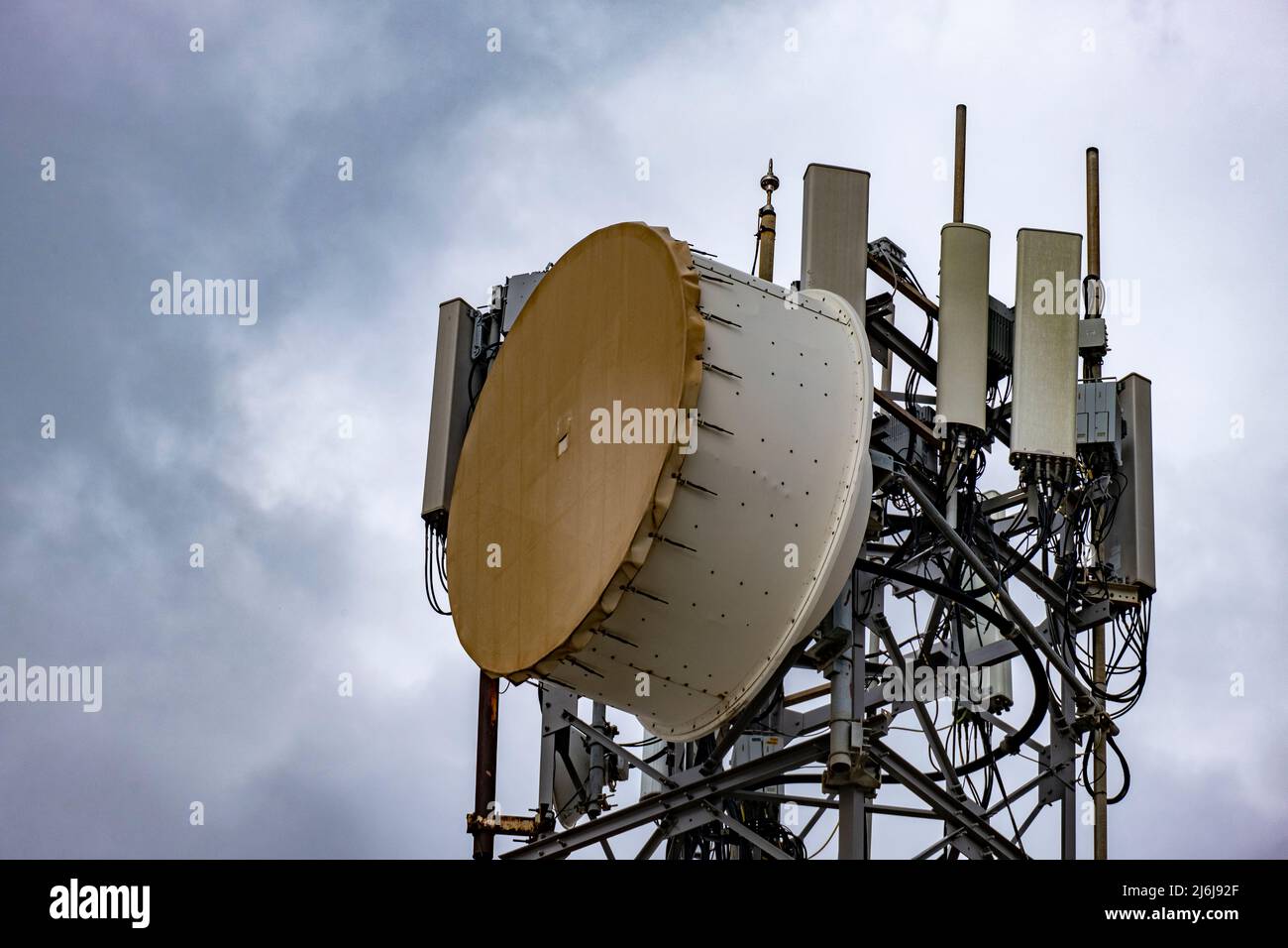 Bass drum style microwave antennas on tall tower. 5G Cellular communication for mobile phone and video data transmission. Telecommunication point Stock Photo