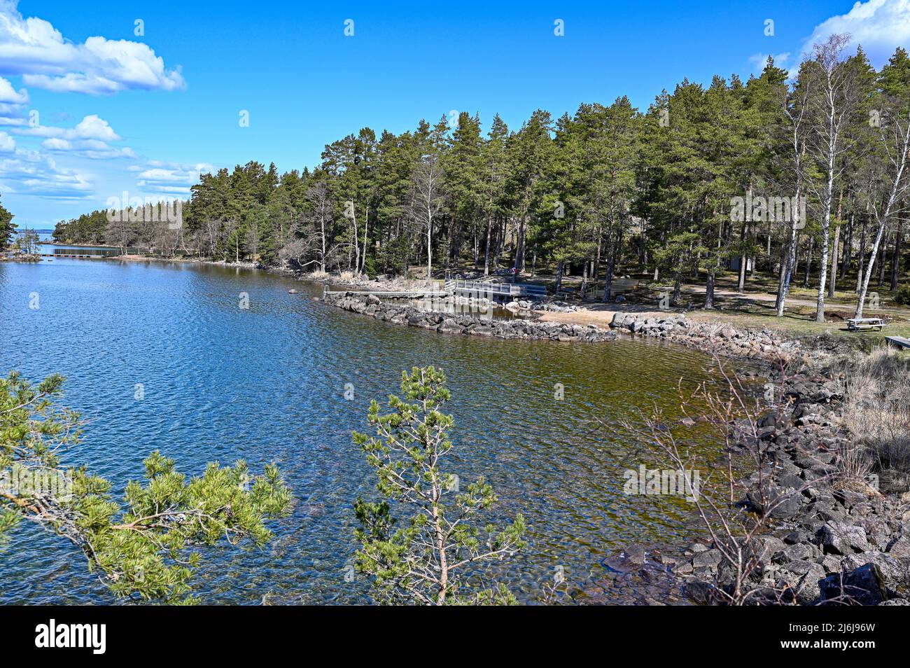 Looking out over lake Vattern and a little beach with a jetty Stock Photo