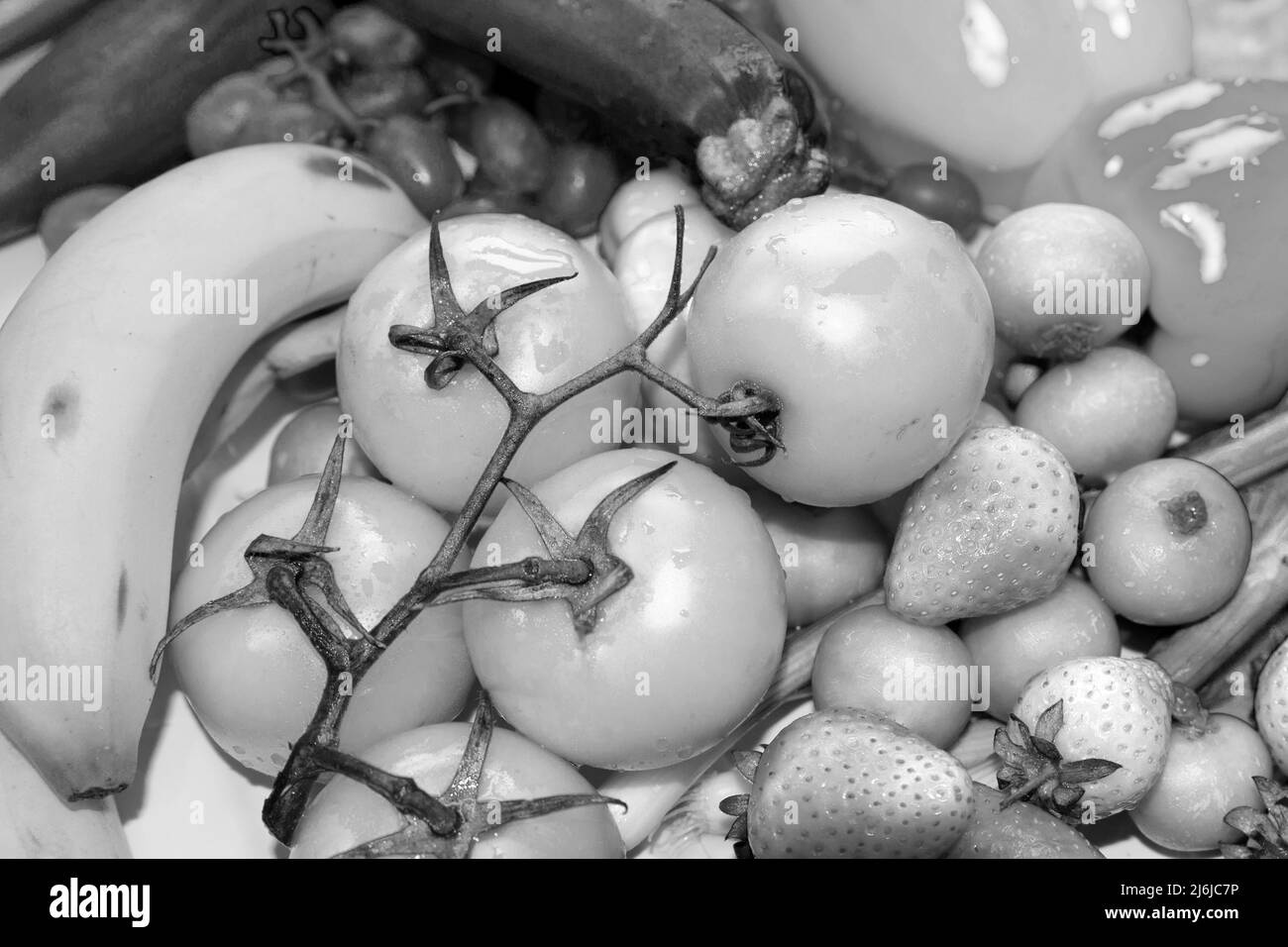 close up black and white  image of fresh fruit,  A variety of succulent organic produce,  including  mouth watering tomatoes, strawberries Stock Photo