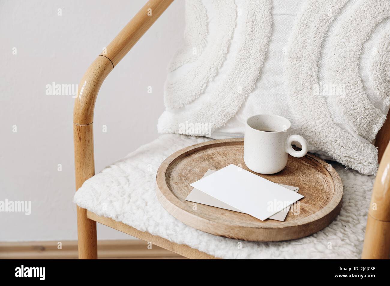 Trendy Scandinavian interior still life. Breakfast concept. Blank greeting card, invitation and cup of coffee on wooden tray. Stationery mock-up Stock Photo