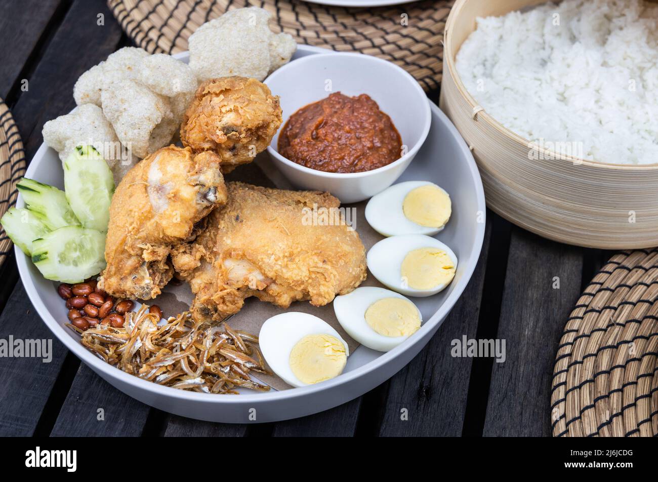 Nasi lemak with fried chicken, anchovis, eggs, groundnuts and sambal is popular Malaysia delicacy, served with rice cooked in coconut milk Stock Photo