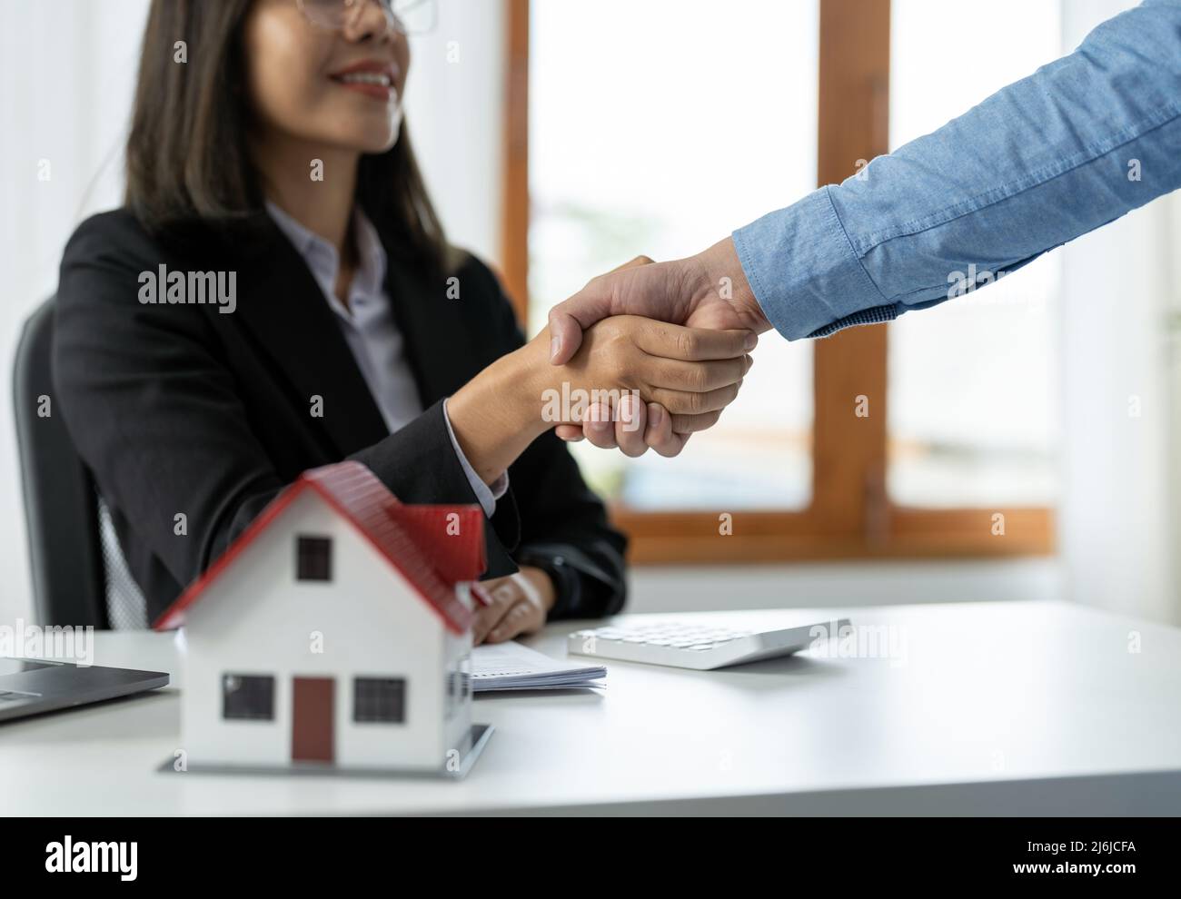 Real estate agents and customers shake hands to congratulate on signing