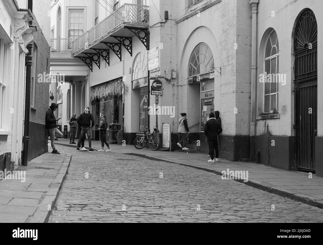 Young people loitering on a narrow cobbled street in Boston, UK Stock Photo