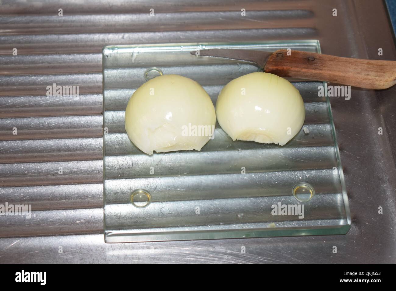 onion cut in half with an ancient knife Stock Photo - Alamy