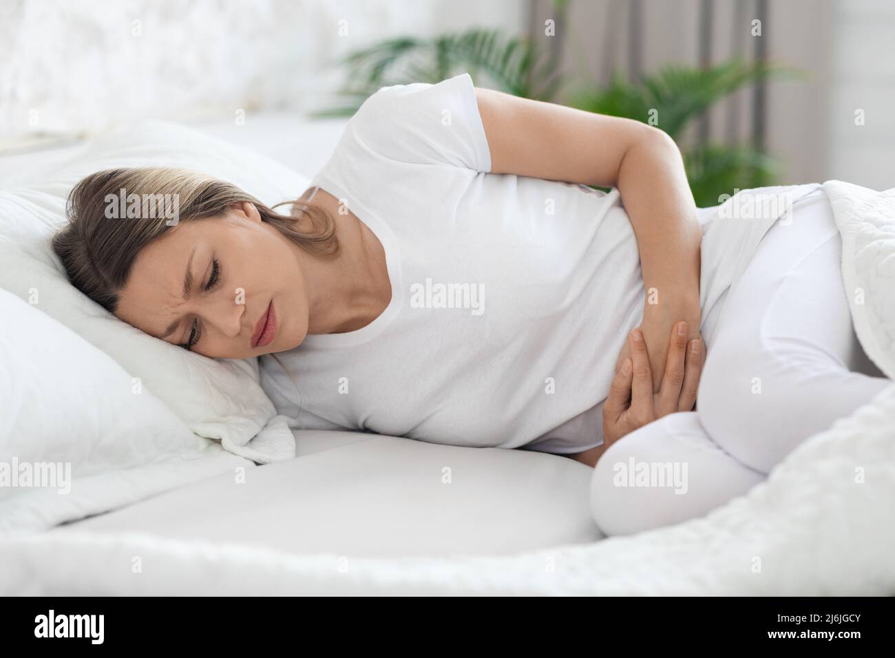 Sick woman suffering from abdominal pain in the morning Stock Photo Alamy