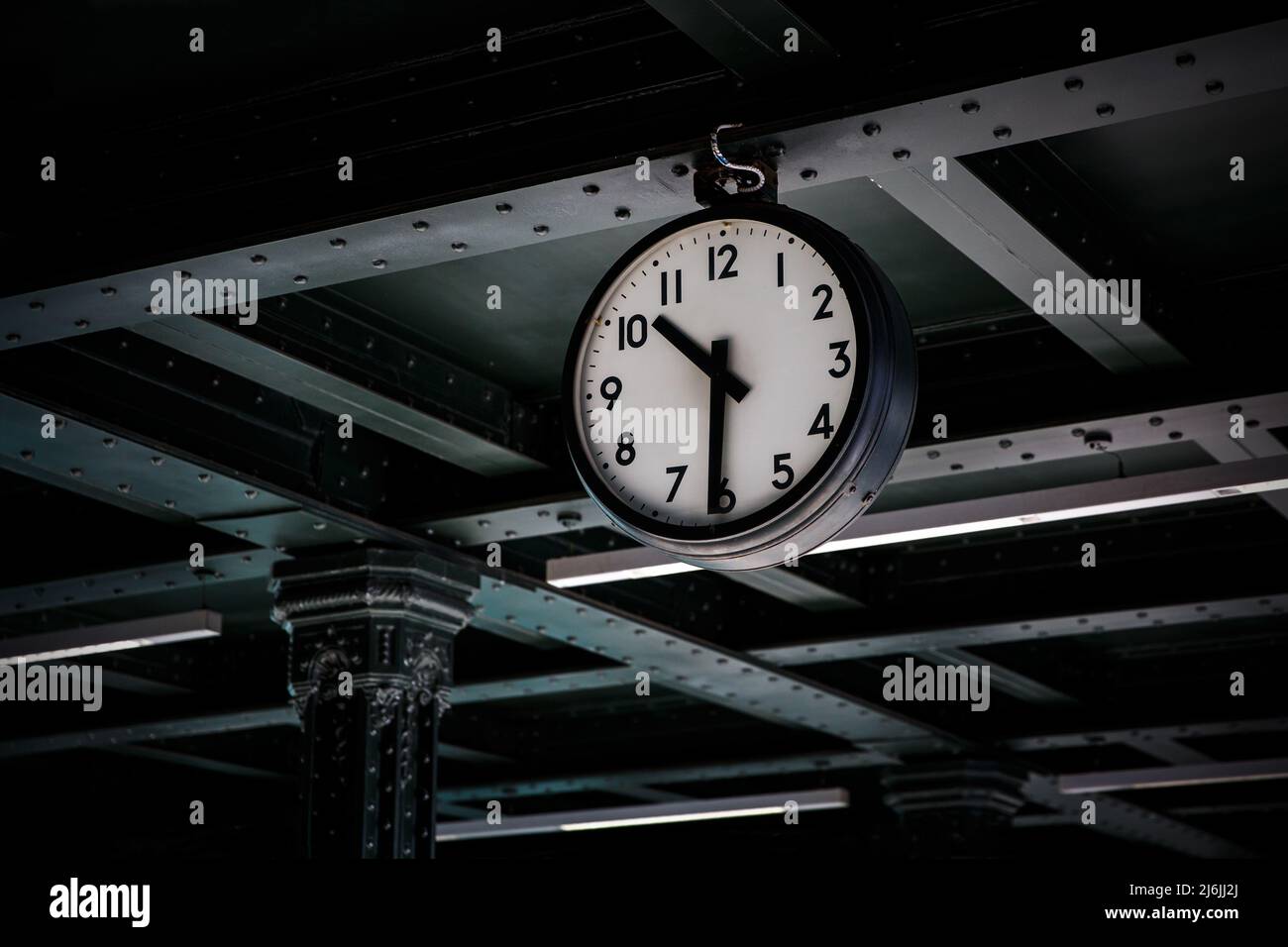 Old vintage style clock on a railway station. Half past eleven on the dial Stock Photo