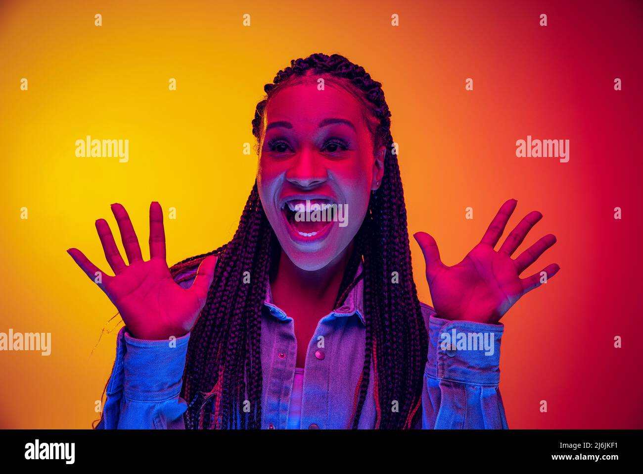 Closeup portrait of shouting isolated on gradient yellow pink background in neon light. Concept of beauty, art, fashion, youth and emotions Stock Photo
