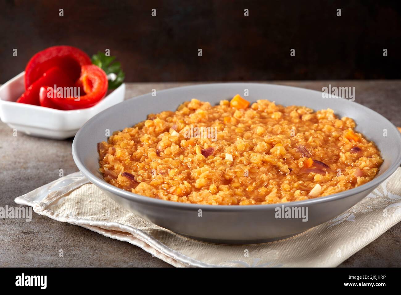 Lentil stew with onion and tomato sauce and pickles in background Stock Photo