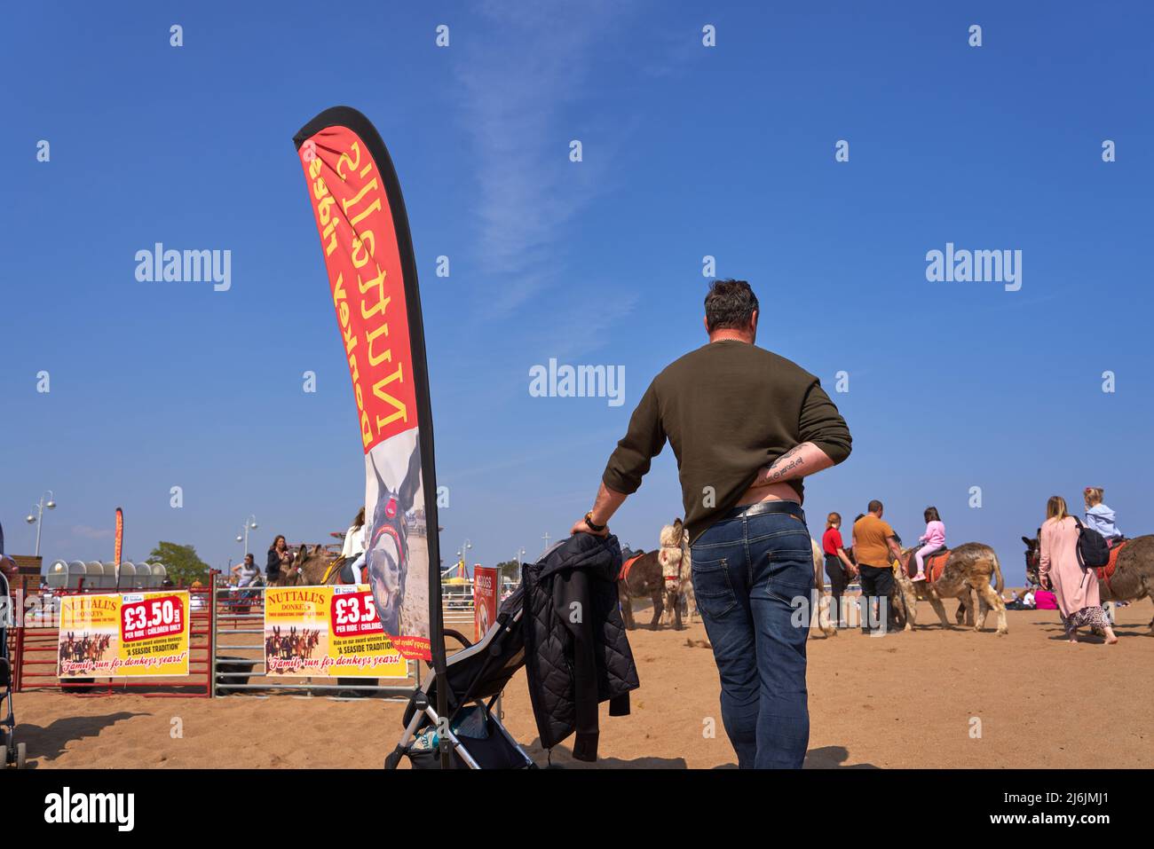 Man with pushchair on a beach in Skegness, UK Stock Photo Alamy