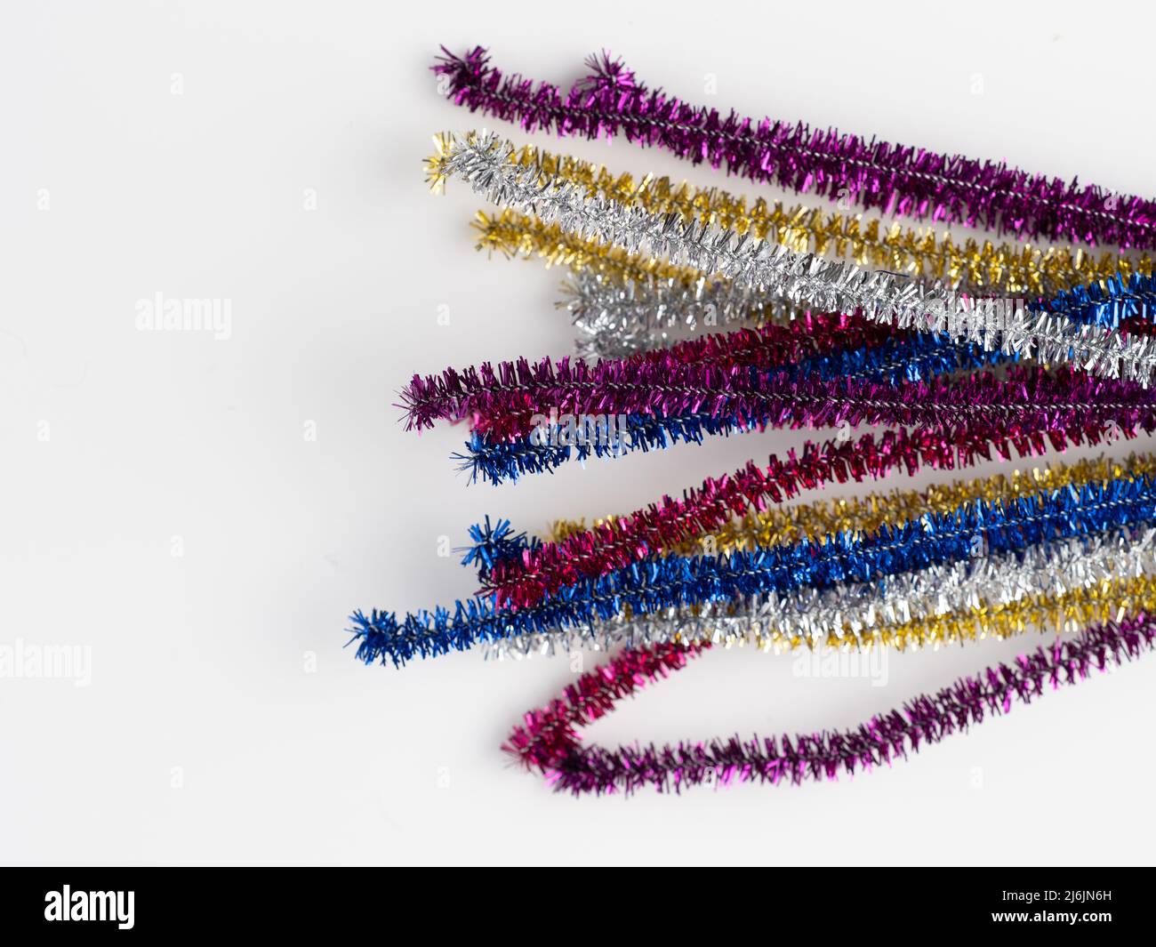 rainbow sparkly pipe cleaners on a white background Stock Photo