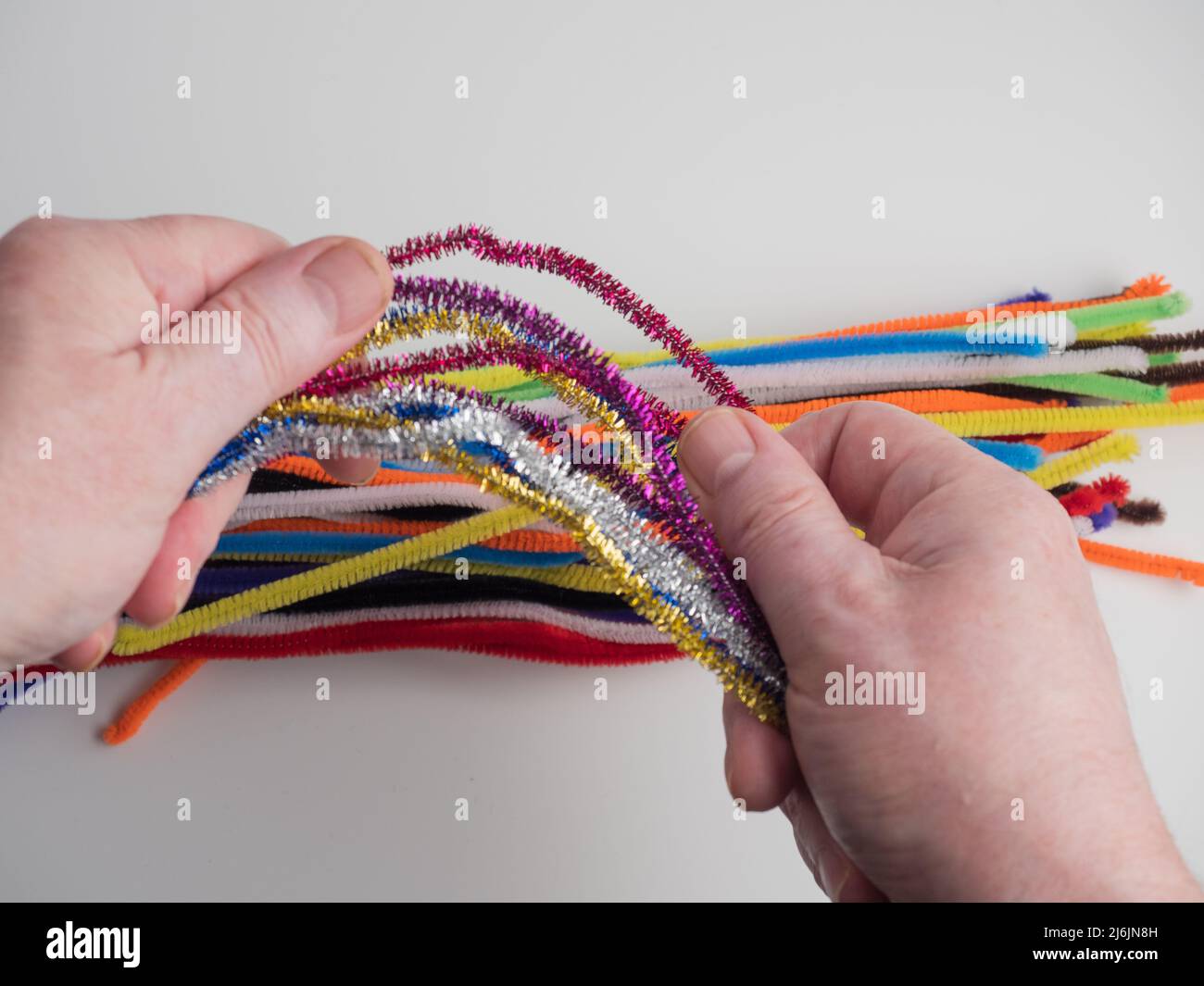 person holding a bunch of sparkly pipe cleaners Stock Photo Alamy