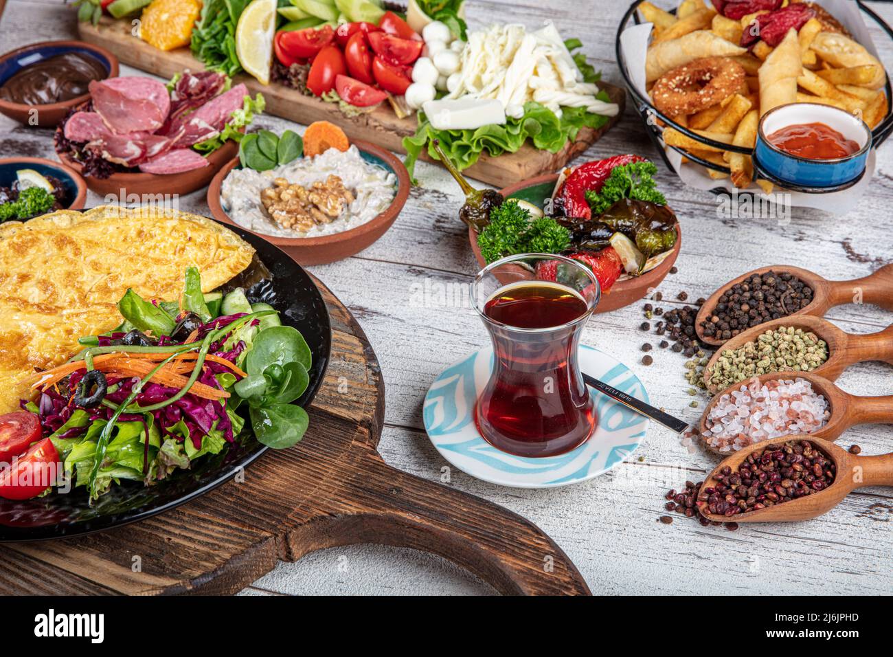 Turkish breakfast table. Pastries, vegetables, greens, olives, cheeses, omelette, spices, jams
