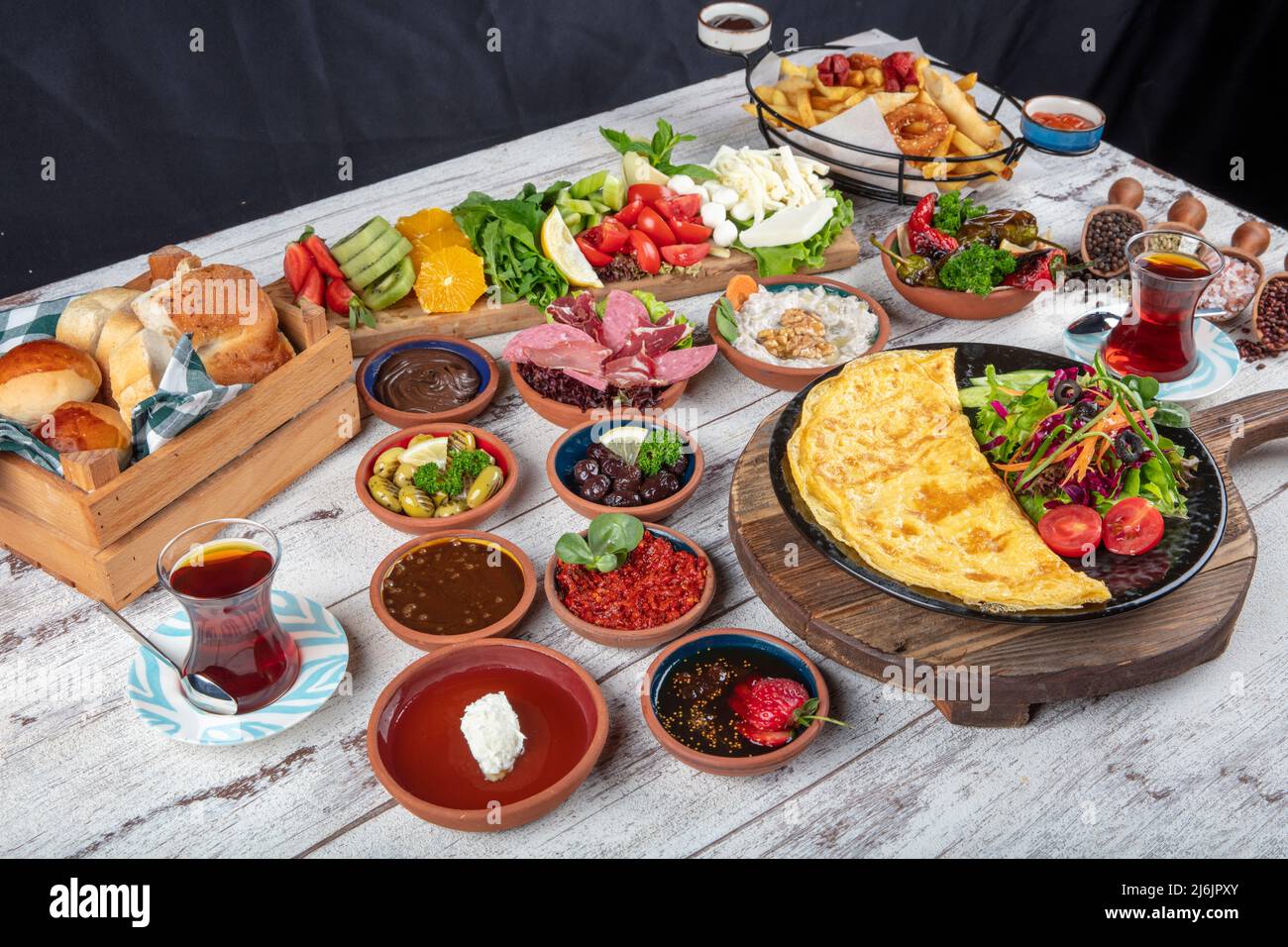 Turkish breakfast table. Pastries, vegetables, greens, olives, cheeses, omelette, spices, jams