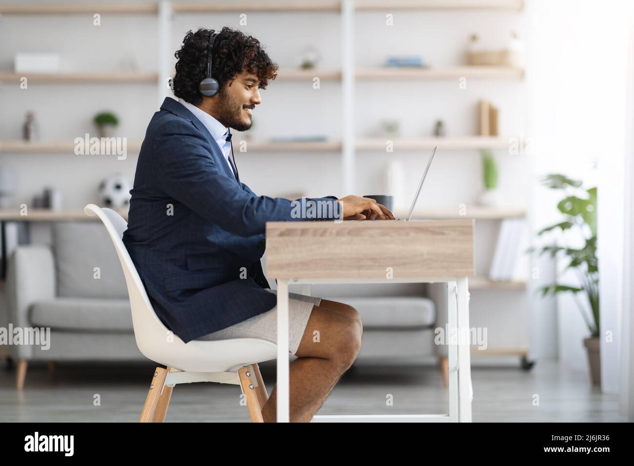 Young indian guy working from home while pandemic, copy space Stock Photo