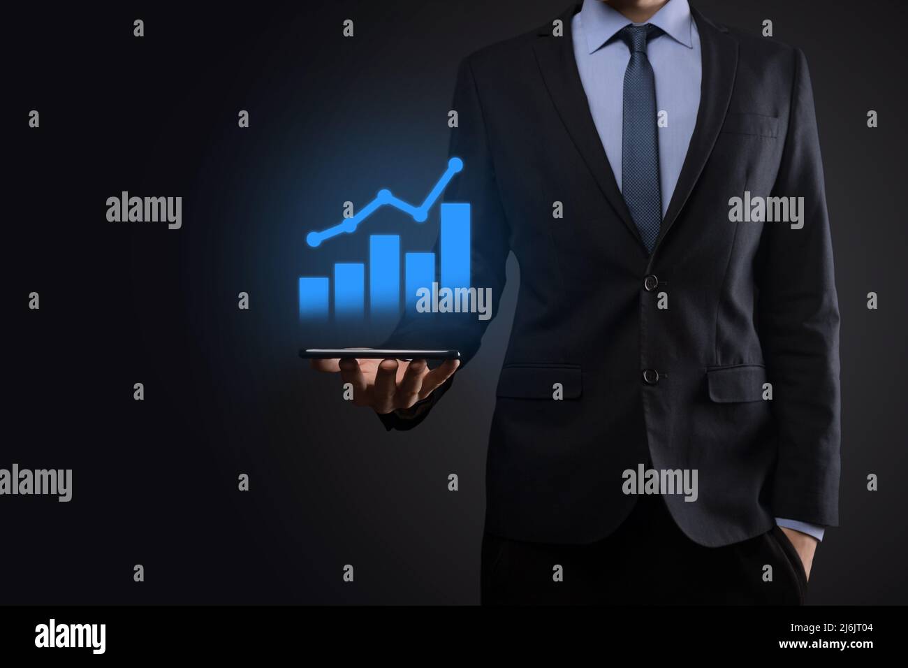 Businessman holding tablet and showing a growing virtual hologram of ...