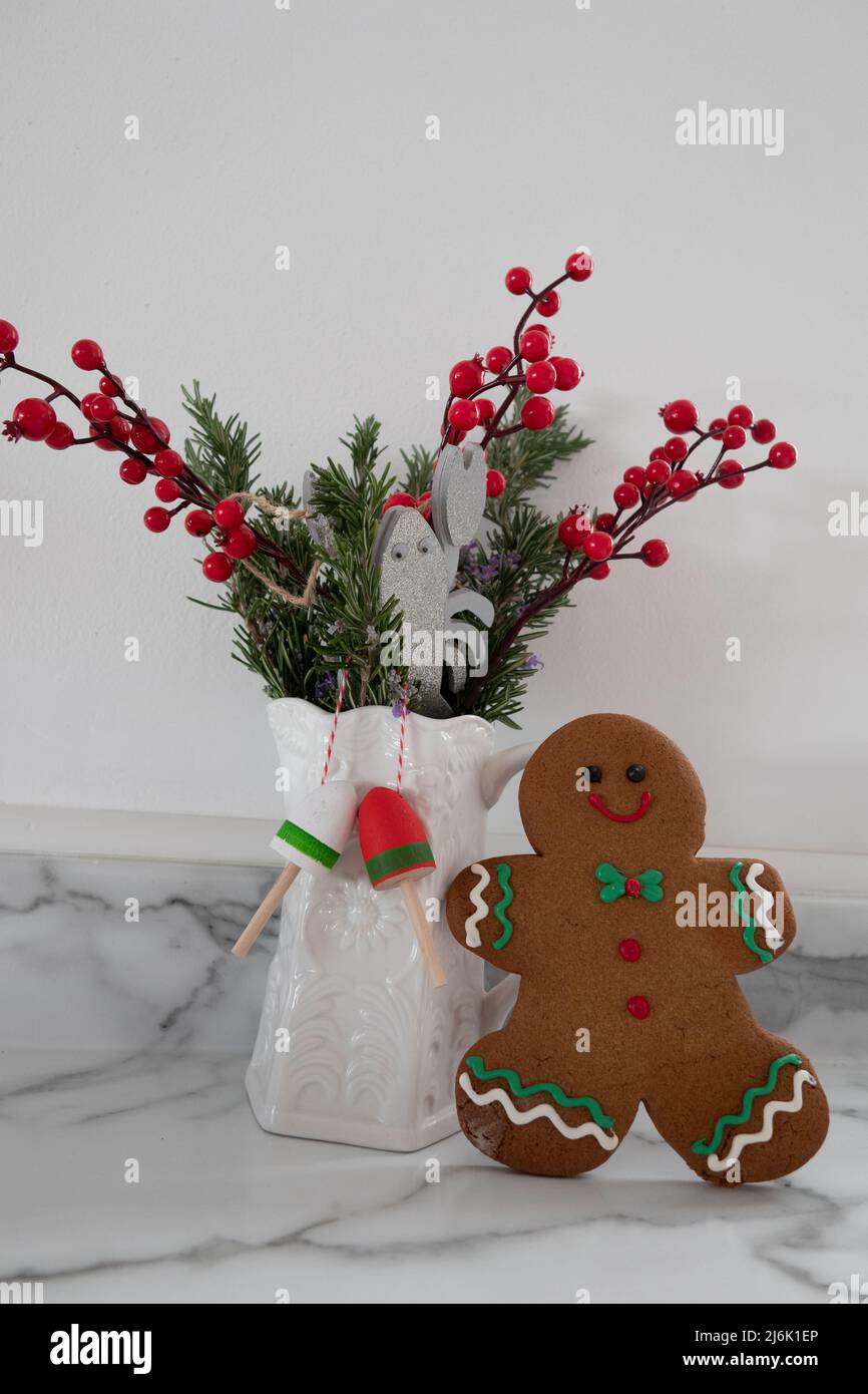 Display with Gingerbread man cookie with Christmas red berries white jug lobsters and buoy's on a light background Stock Photo