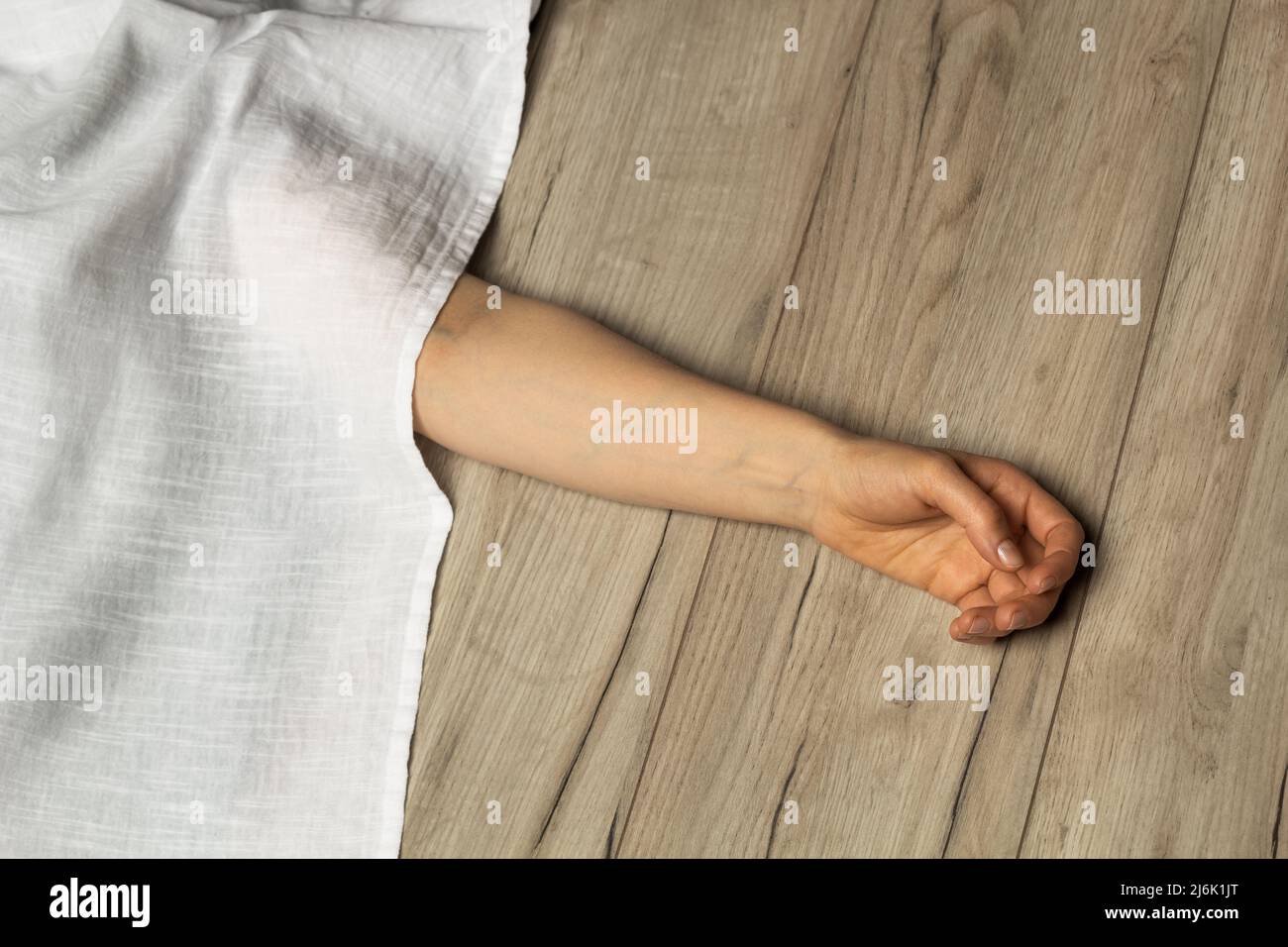 Dead woman's hand covered with a sheet. Stock Photo