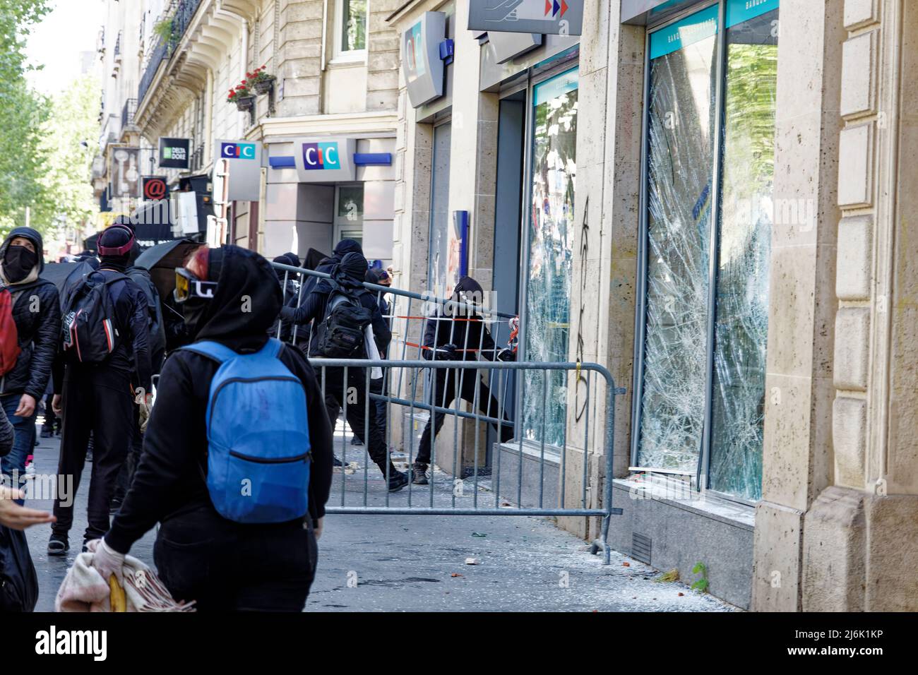 Paris, France. 1st May, 2022. Hooded thugs destroy a shop window during the May Day 2022 protest in Paris, France. Stock Photo