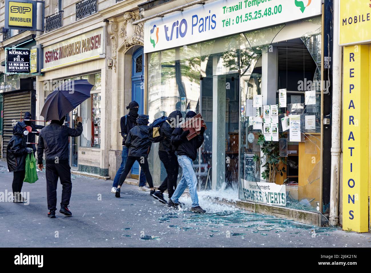 Paris, France. 1st May, 2022. Hooded thugs destroy a shop window during the May Day 2022 protest in Paris, France. Stock Photo