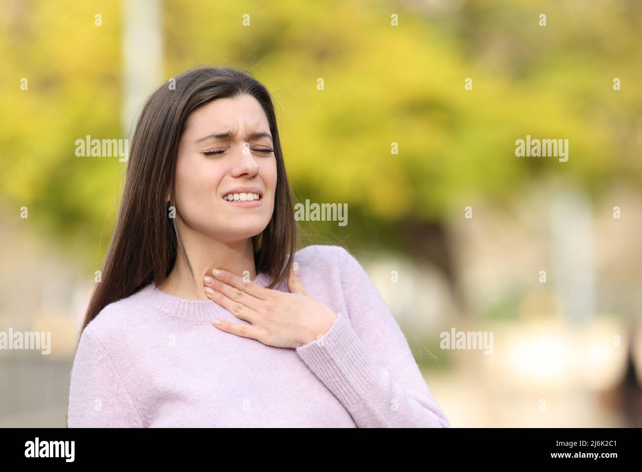 Teen suffering sore throat walking in a park Stock Photo