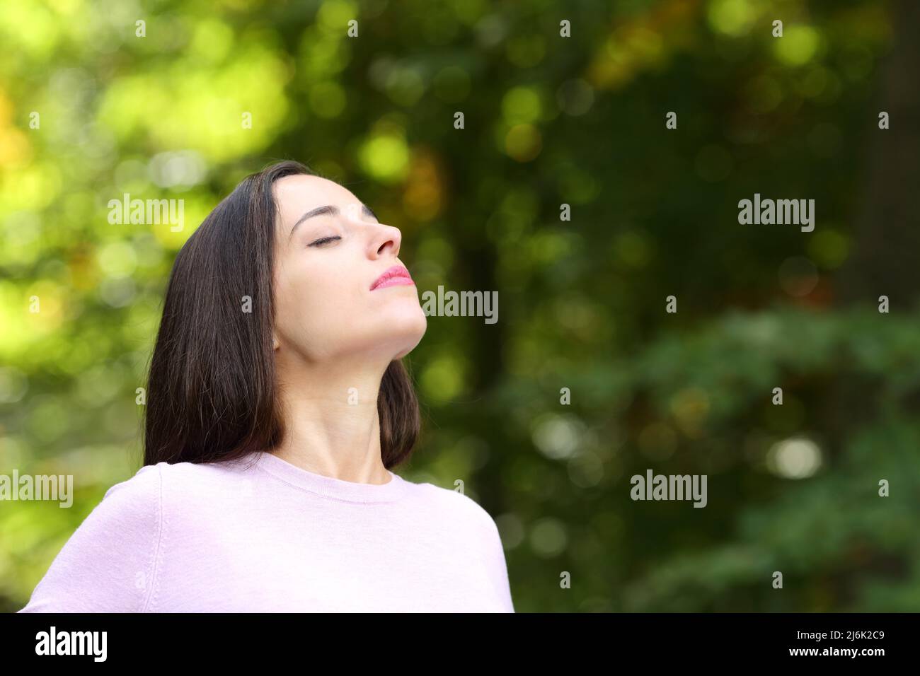 Woman relaxing breathing fresh air standing in a green park Stock Photo ...