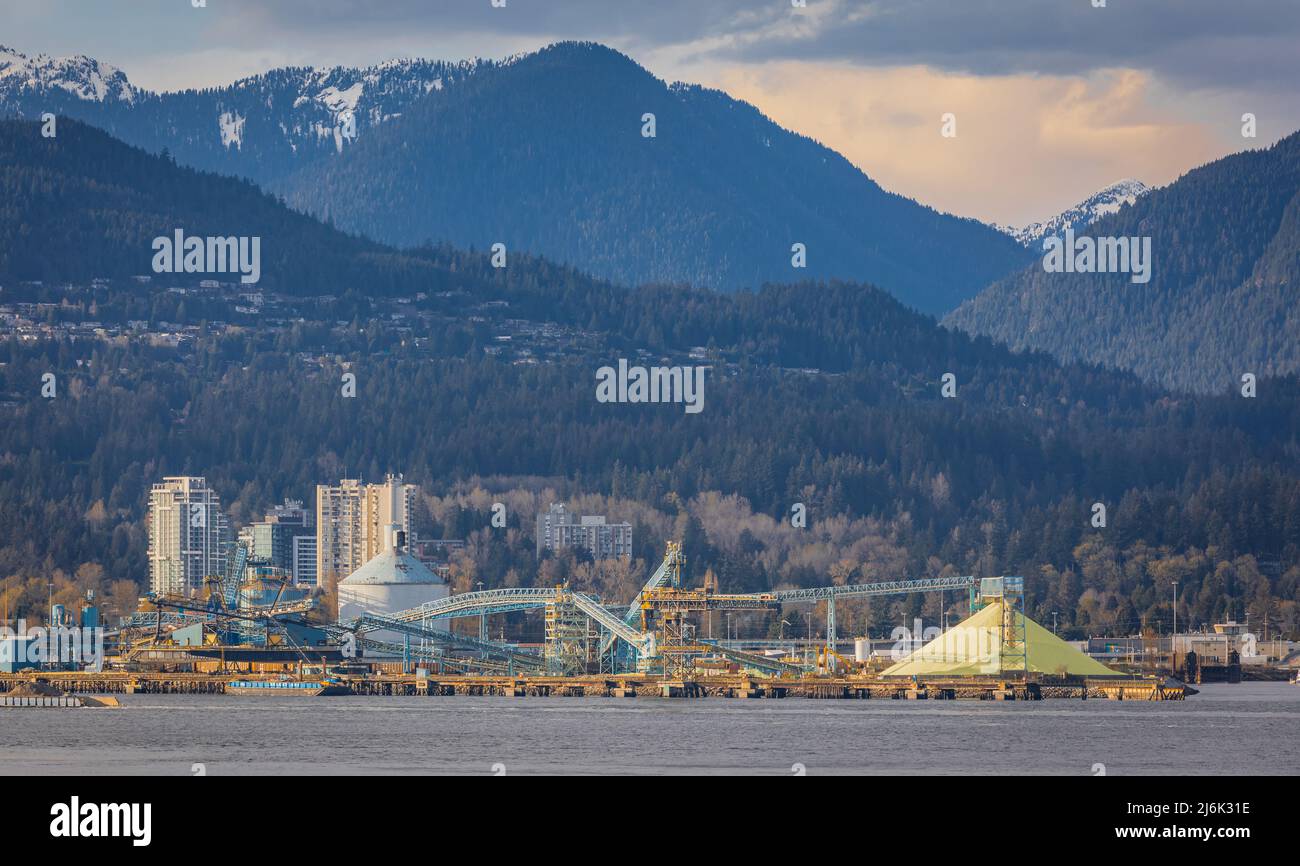 Port facility for grains, oil seeds and pulses. Grain elevator, silos and industrial buildings Vancouver BC, Canada. Big stacks of Sulphur Stock Photo