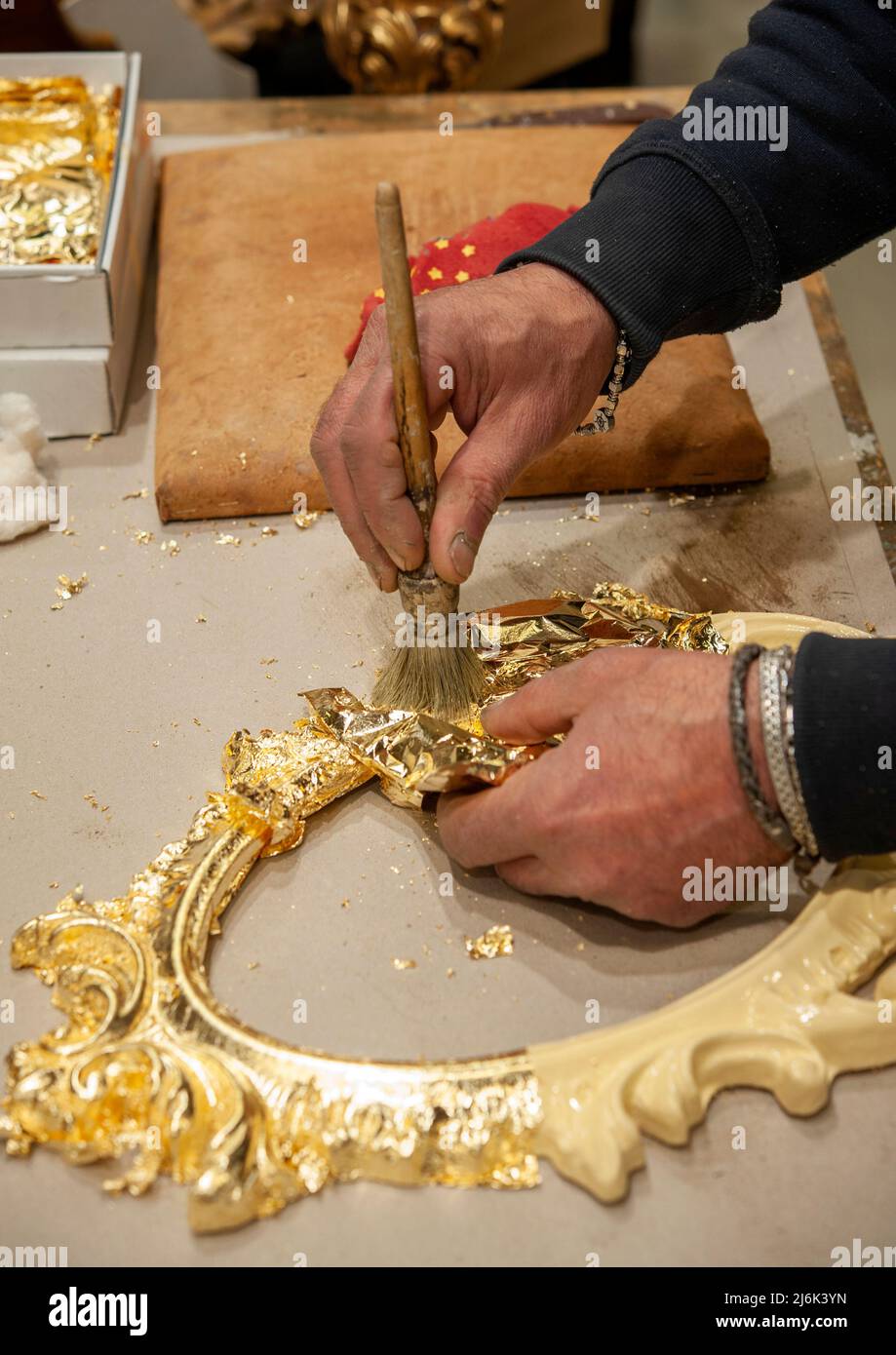 Application of gold leaf to a frame. Gilding process technique Stock
