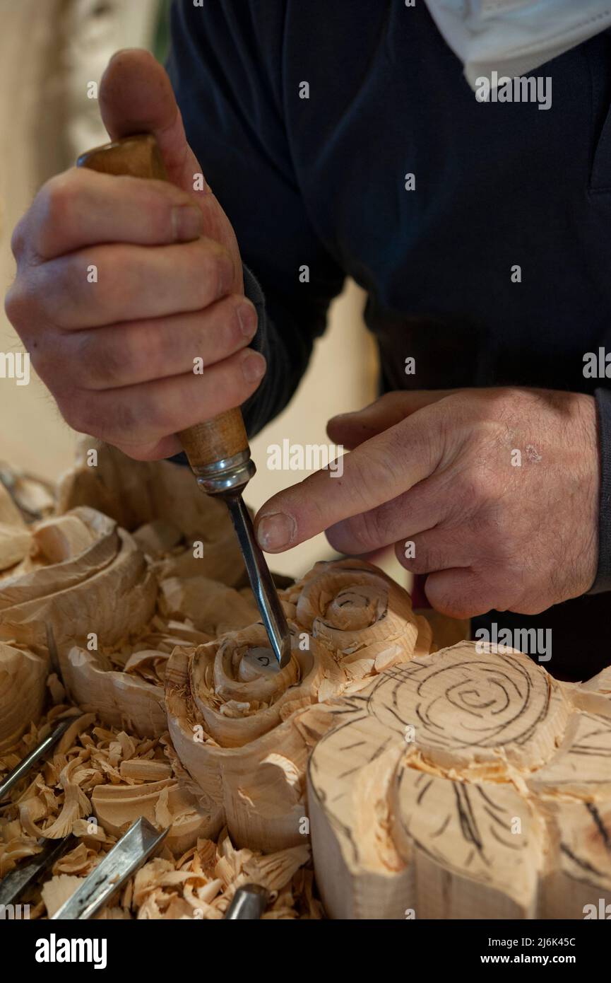 Master woodcarver at work. Wood shavings, gouges and chisels on the workbench. Stock Photo