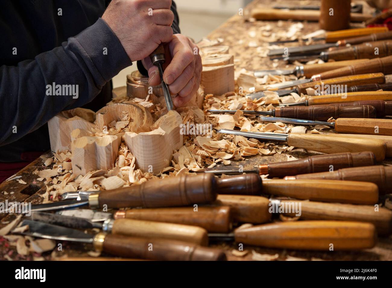 Master woodcarver at work. Wood shavings, gouges and chisels on the ...
