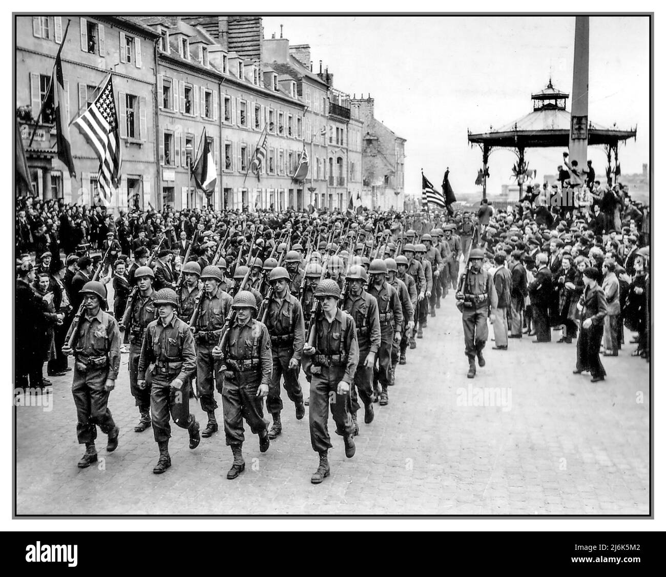 WW2 LIBERATION FRANCE NAZIS CHERBOURG  American troops march through Place de la Republique after D-Day to the cheers and waves of the local French population Cherbourg , France June 27, 1944. World War II Second World War Stock Photo