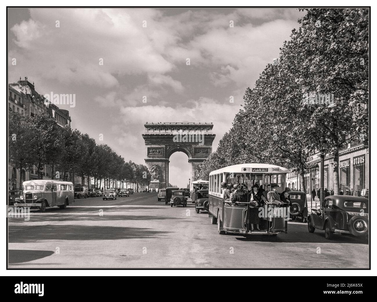 PARIS Vintage 1930's retro Paris 1936 Arc de Triomphe and traffic on the Champs-Elysees including Parisian Autobus and people wearing the styles and fashion of the day. Pre WW2 Buses street scene archive French B&W Photographer Willem van de Poll Stock Photo