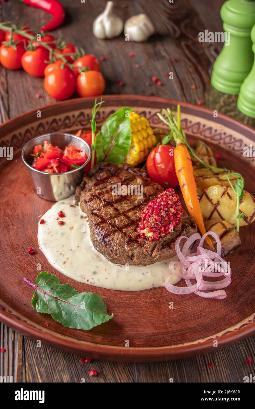 Filet mignon steak served with grilled vegetables, mushrooms and cheese sauce, restaurant dish