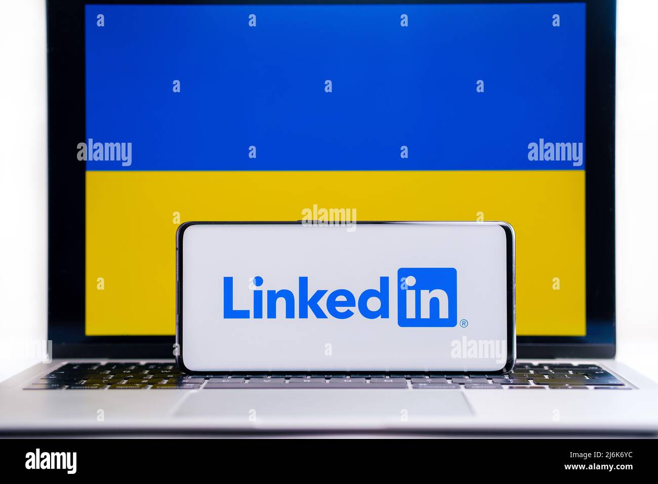 LinkedIn company logo on smartphone and Ukrainian flag on the background. Concept. Stafford, UK, March 20, 2022 Stock Photo