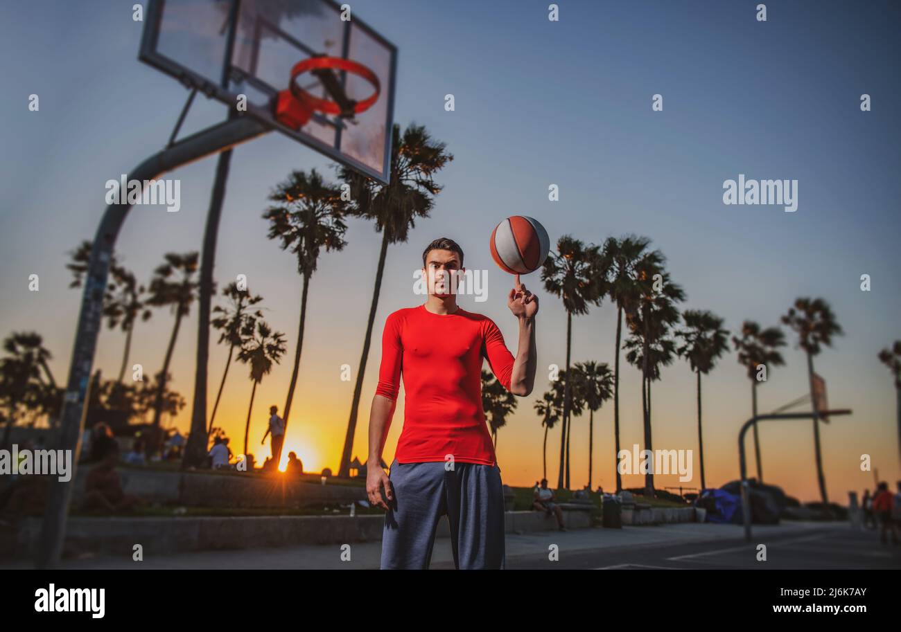 hold basketball ball on Venice beach basketball court. Hand spinning