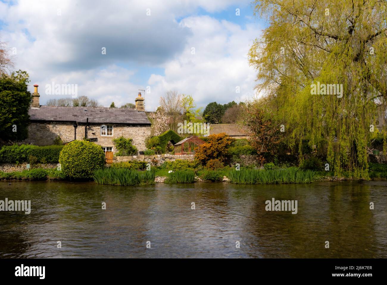 Cottage beside the River Wye at Ashford in the Water, near Bakewell, Derbyshire, UK Stock Photo