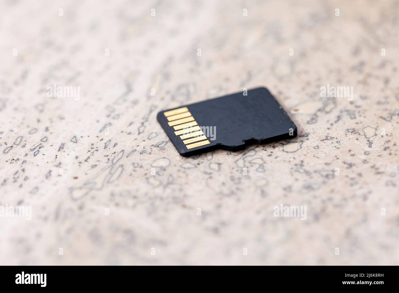 A close up portrait of the back of a black micro SD card, the connectors of the small piece of storage electronics hardware is visible. Stock Photo