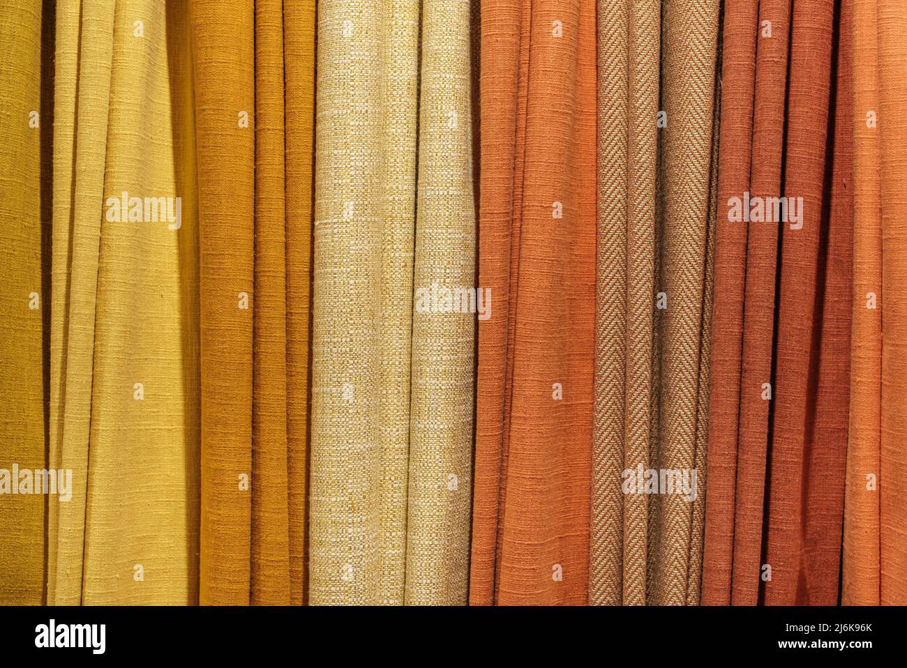 Background Texture Of A Selection Of Multiple Different Warm-Colored Fabric Samples Stock Photo