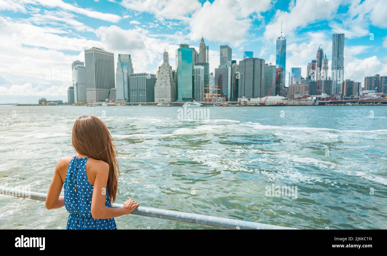 New York city urban woman enjoying view of downtown Manhattan skyline from Brooklyn park living a happy lifestyle walking during summer travel in USA Stock Photo