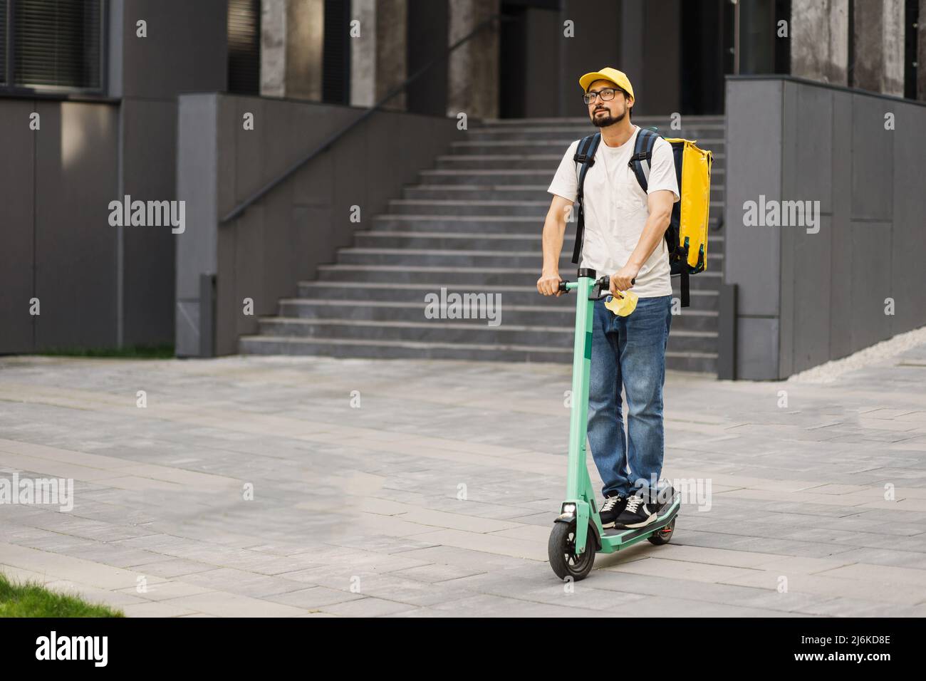 Courier deliver food on electric scooter. Delivering of hot food to