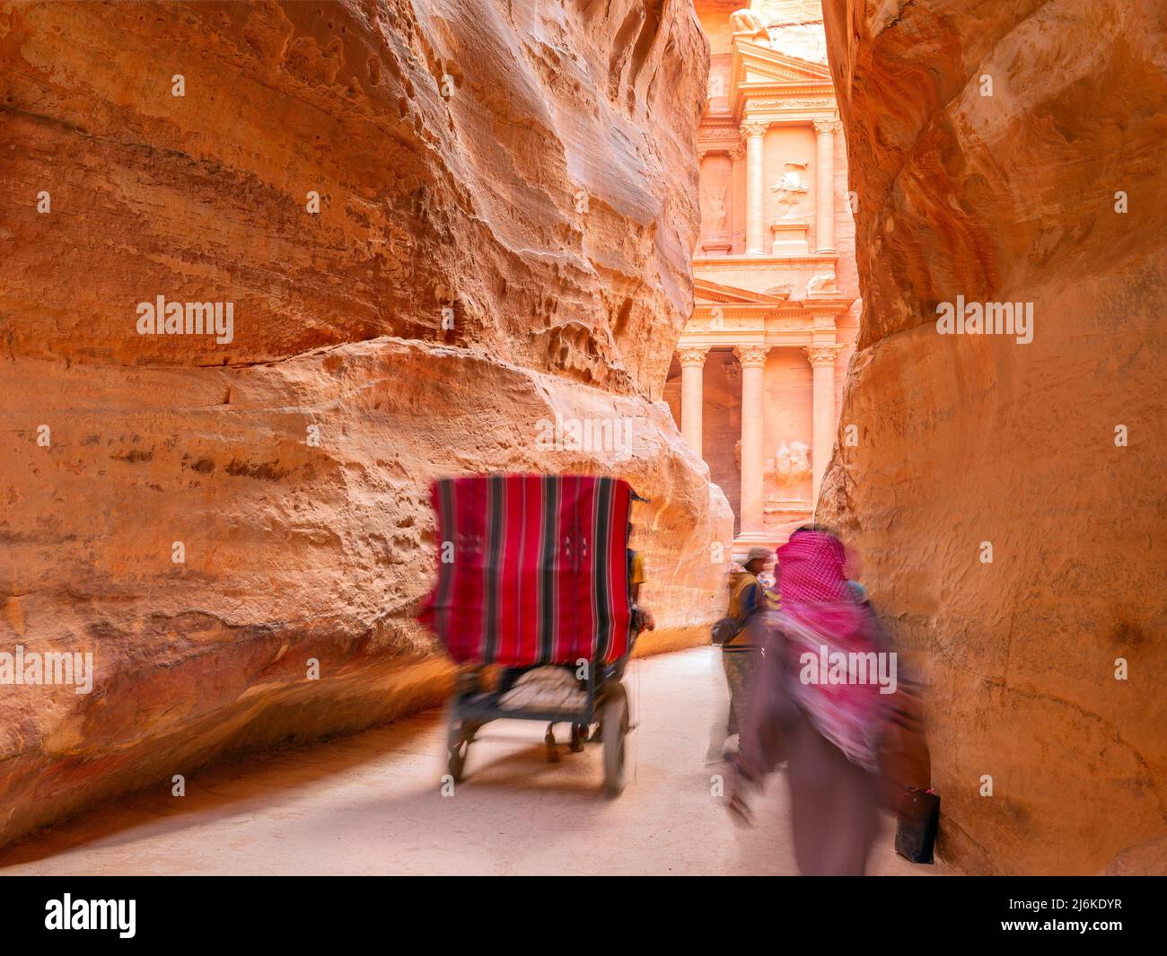 people in a horse carriage in a gorge, Siq canyon in Petra, Jordan. Petra is one of the New Seven Wonders of the World. Stock Photo