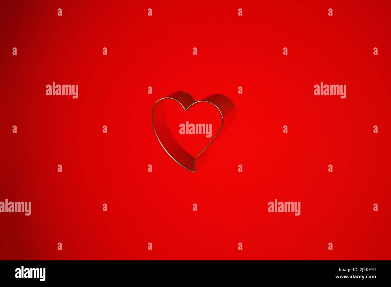Still life of a heart shaped isolated object on a red background Stock Photo