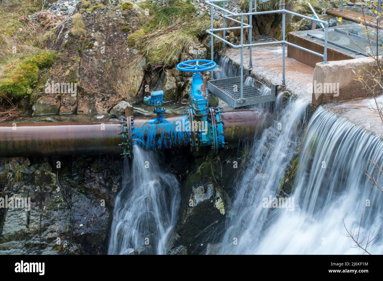 Leaking water pipe and gate valve at Hydroelectric plant water intake, Glenridding, Cumbria, England, UK Stock Photo