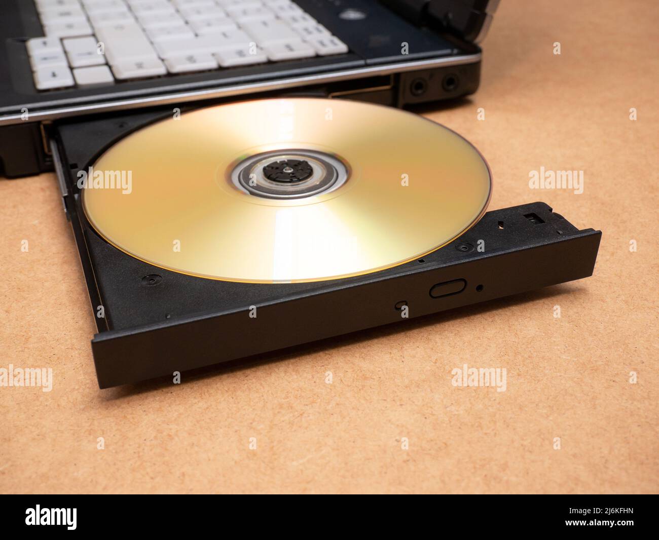CD DVD optical disc media inserted in a laptop computer disc tray, closeup, nobody. Films, movies software data storage and sharing, piracy, installat Stock Photo