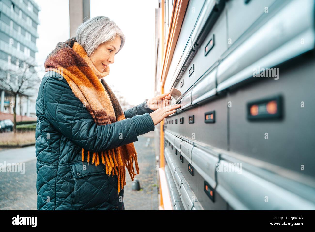 Senior woman gets the bike in a parking Stock Photo