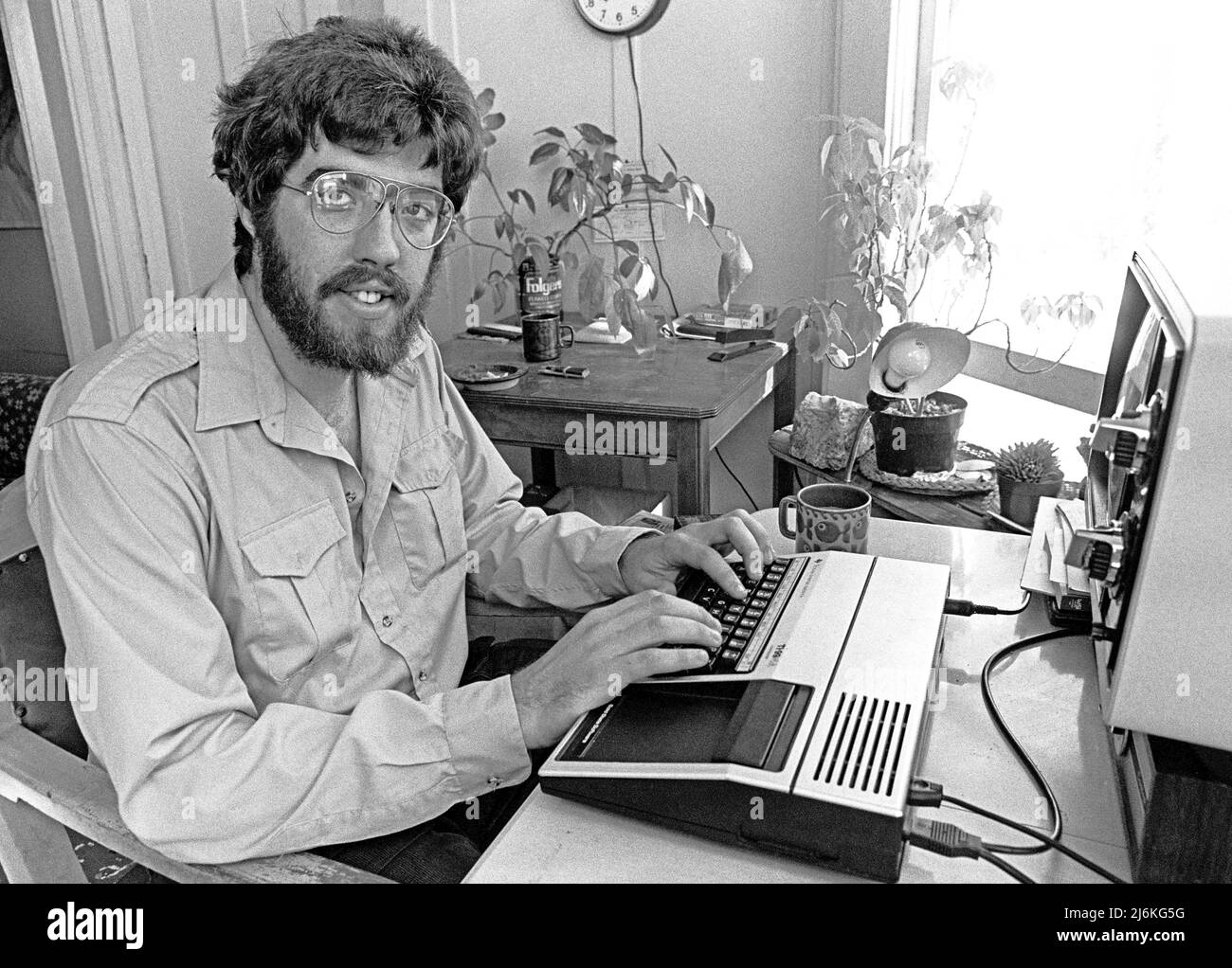 Mike Moore creating games on his TI 99-4a computer based on battles in the Civil War in San Francisco,. saving his game data on a tape recorder, He also created a modem dial up Bulletin Board game called Draken's Keep. September 1983 Stock Photo
