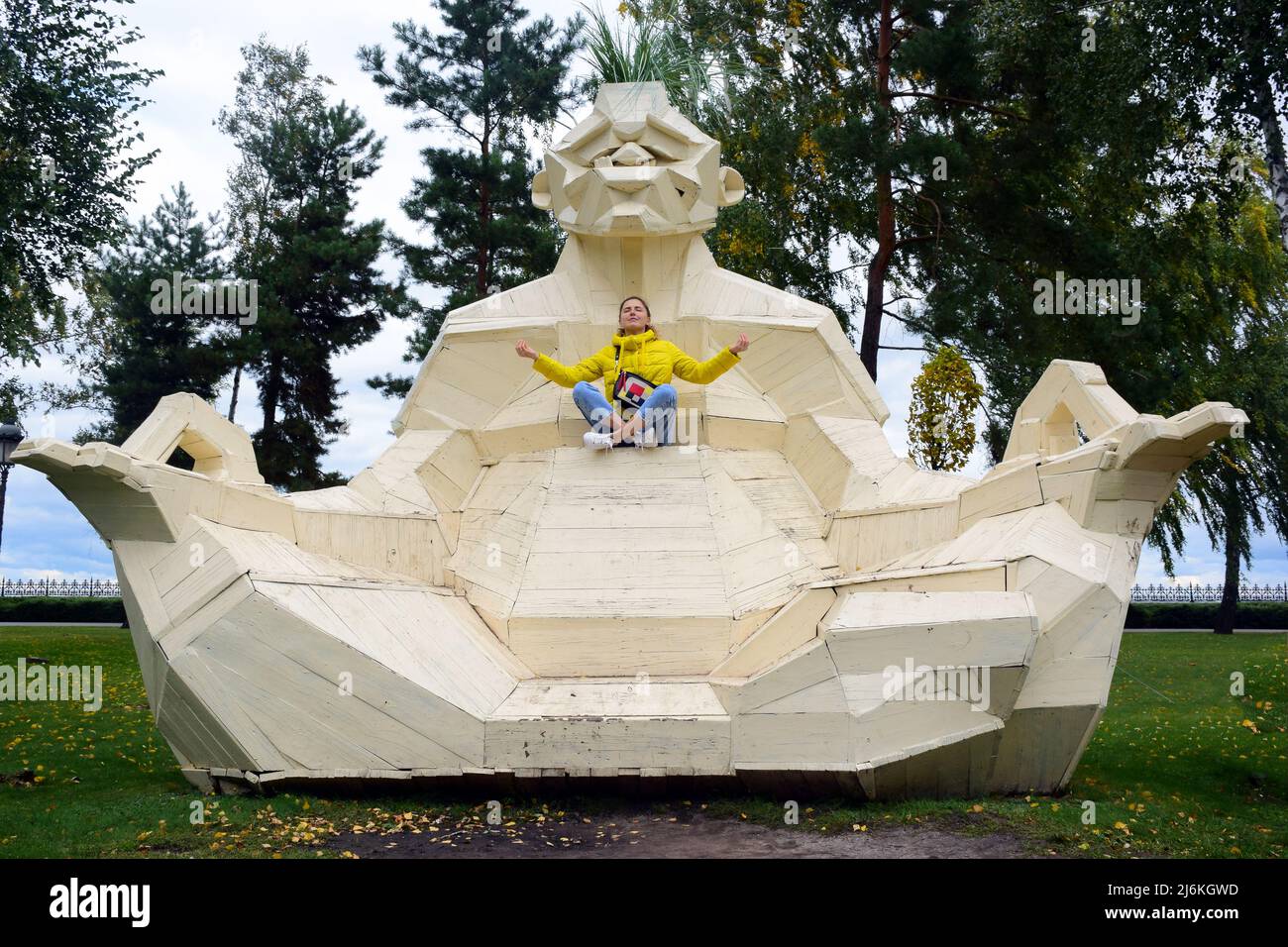 Large decorative statue of a monkey in a zen pose. In her arms is a