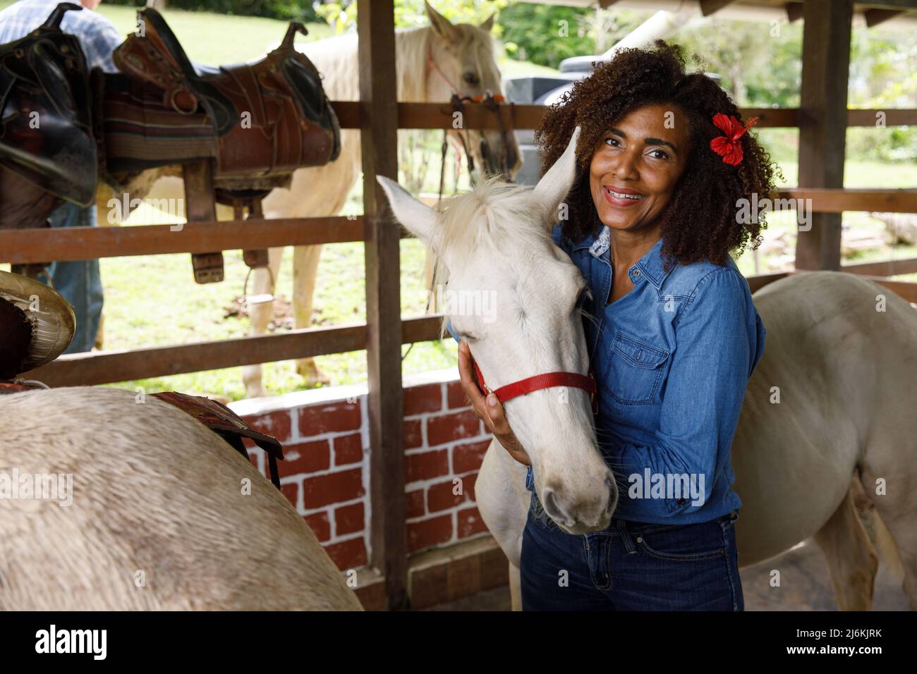 2022.19.03 Dominican Republic. La altagracia La Guama. Portrait of a woman hugging a horse. Dominican people Stock Photo