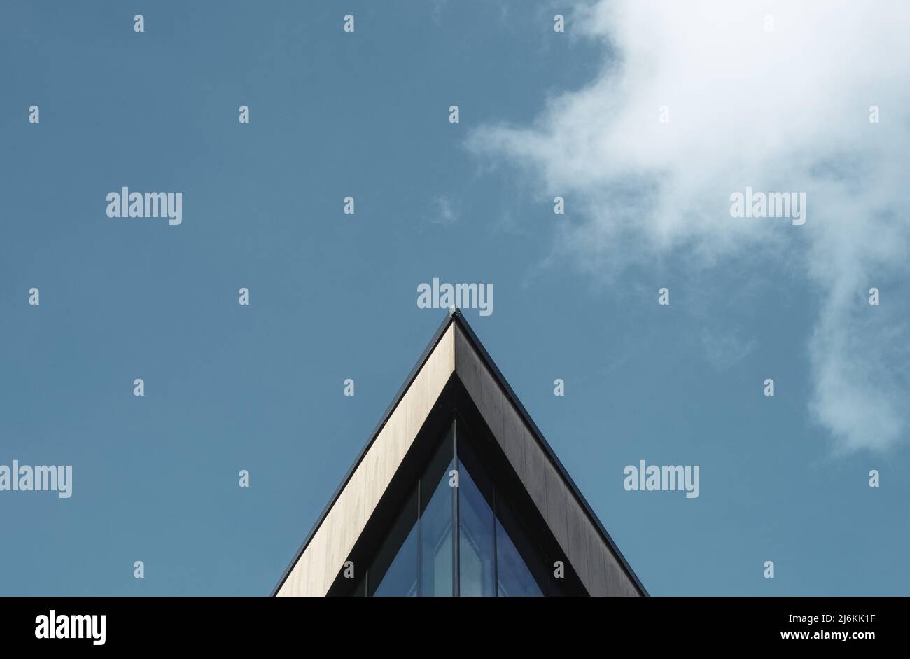 Abstract Architectural Image Of A Triangular Building Against A Blue Sky WIth Clouds And Copy Space Stock Photo